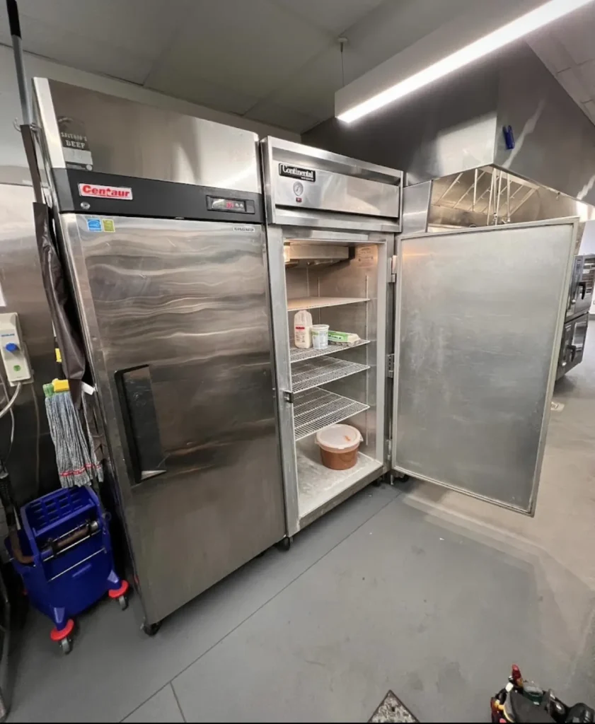 Open stainless commercial reach-in refrigerators during on-site repair