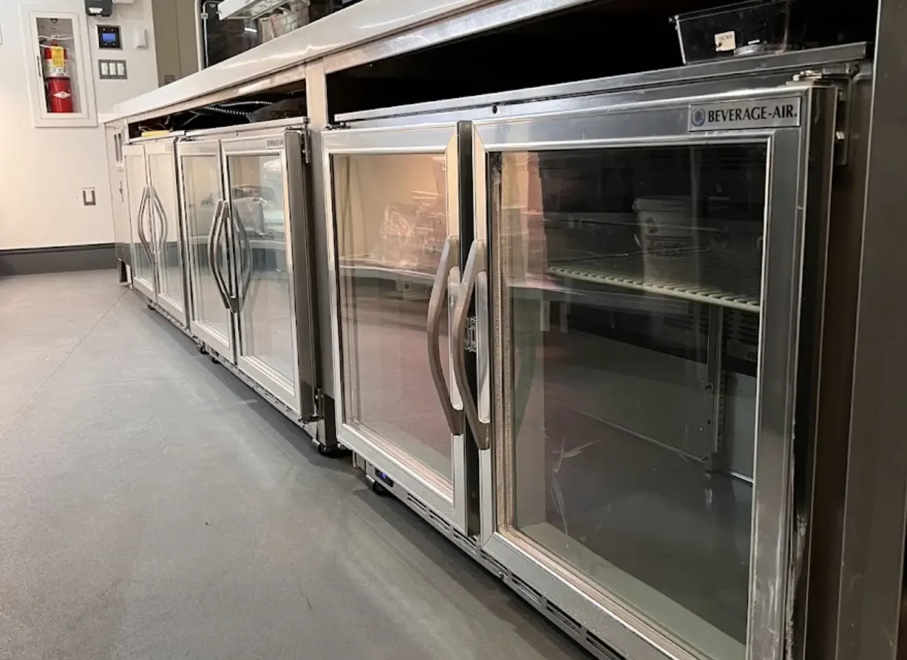 Stainless commercial refrigeration equipment lined up in a professional kitchen