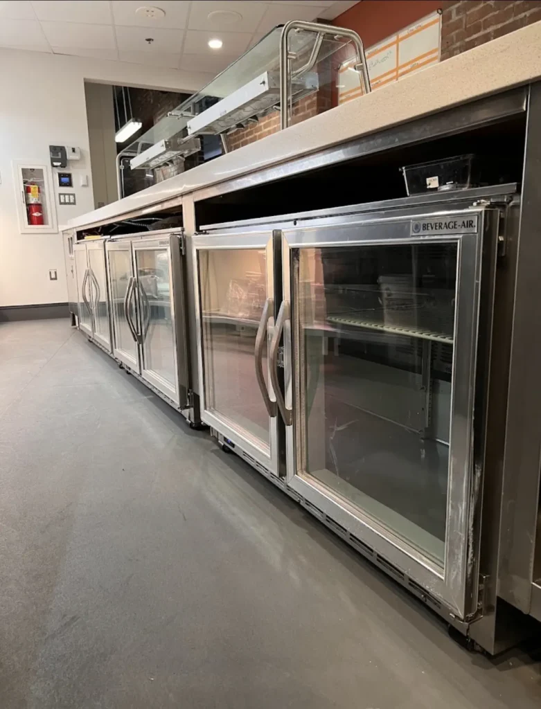 Stainless commercial refrigeration equipment lined up in a professional kitchen