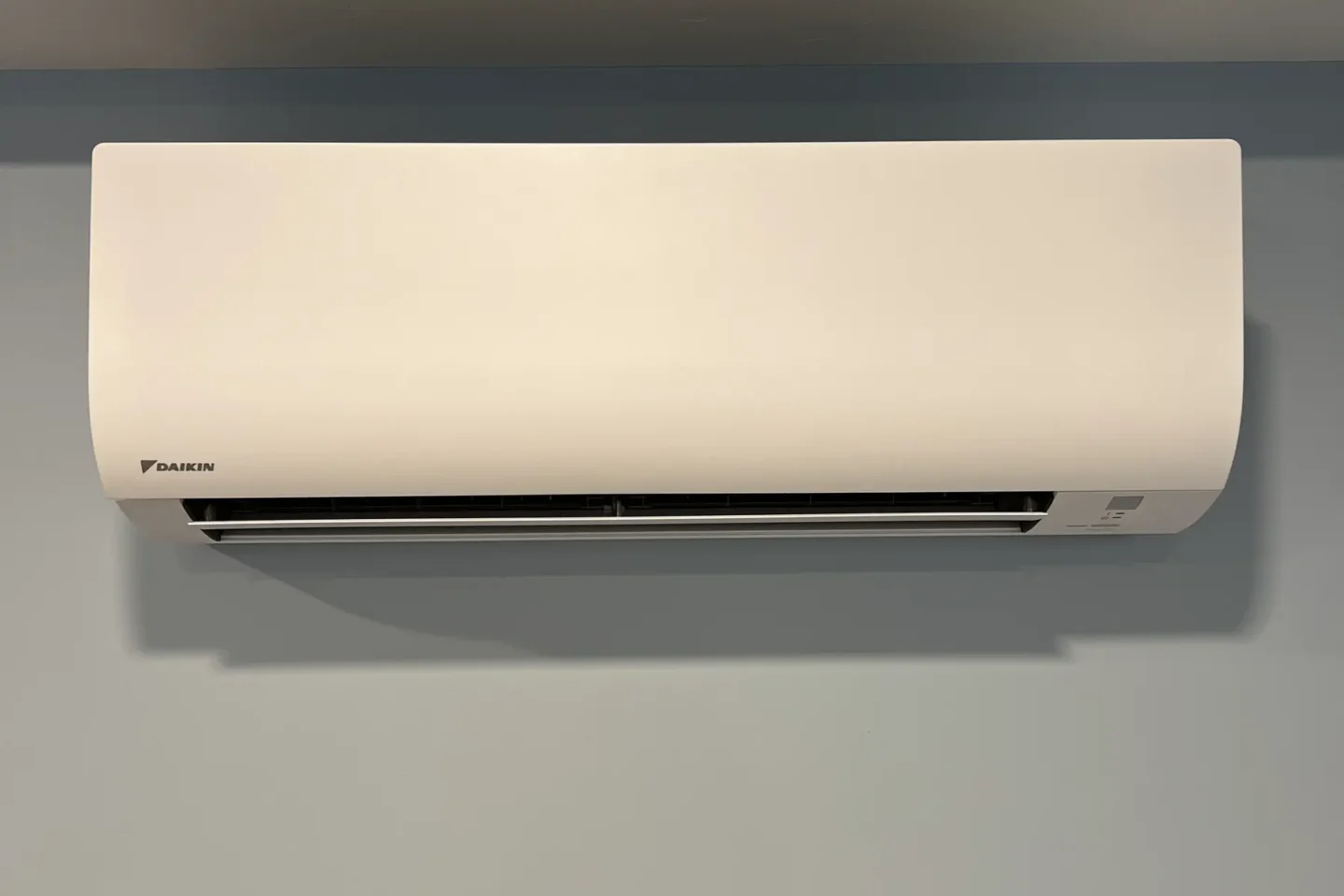 White Daikin ductless mini-split indoor unit installed high on a finished wall