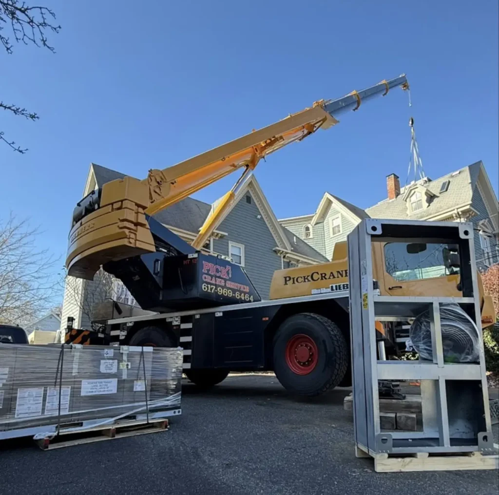 Crane truck lifting packaged HVAC equipment for a residential installation
