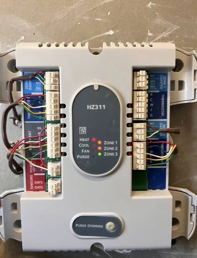 Electronic HVAC zoning control panel with labeled thermostat and damper wiring