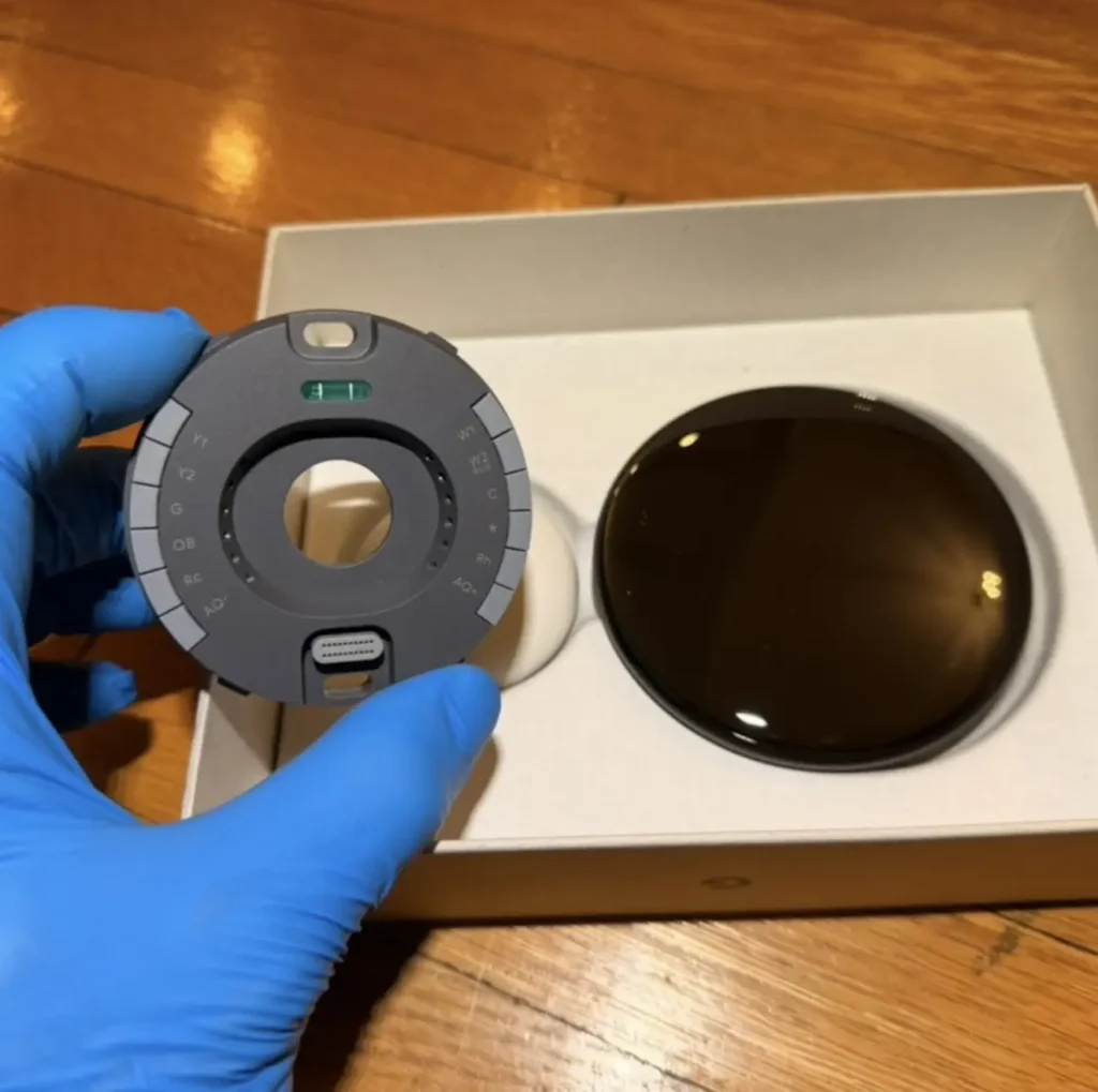 Technician holding a Nest thermostat display beside its mounted wall base