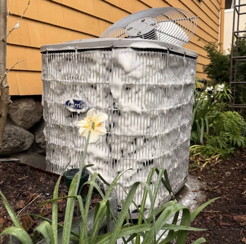 Outdoor condenser coil covered with dirt and debris before professional cleaning