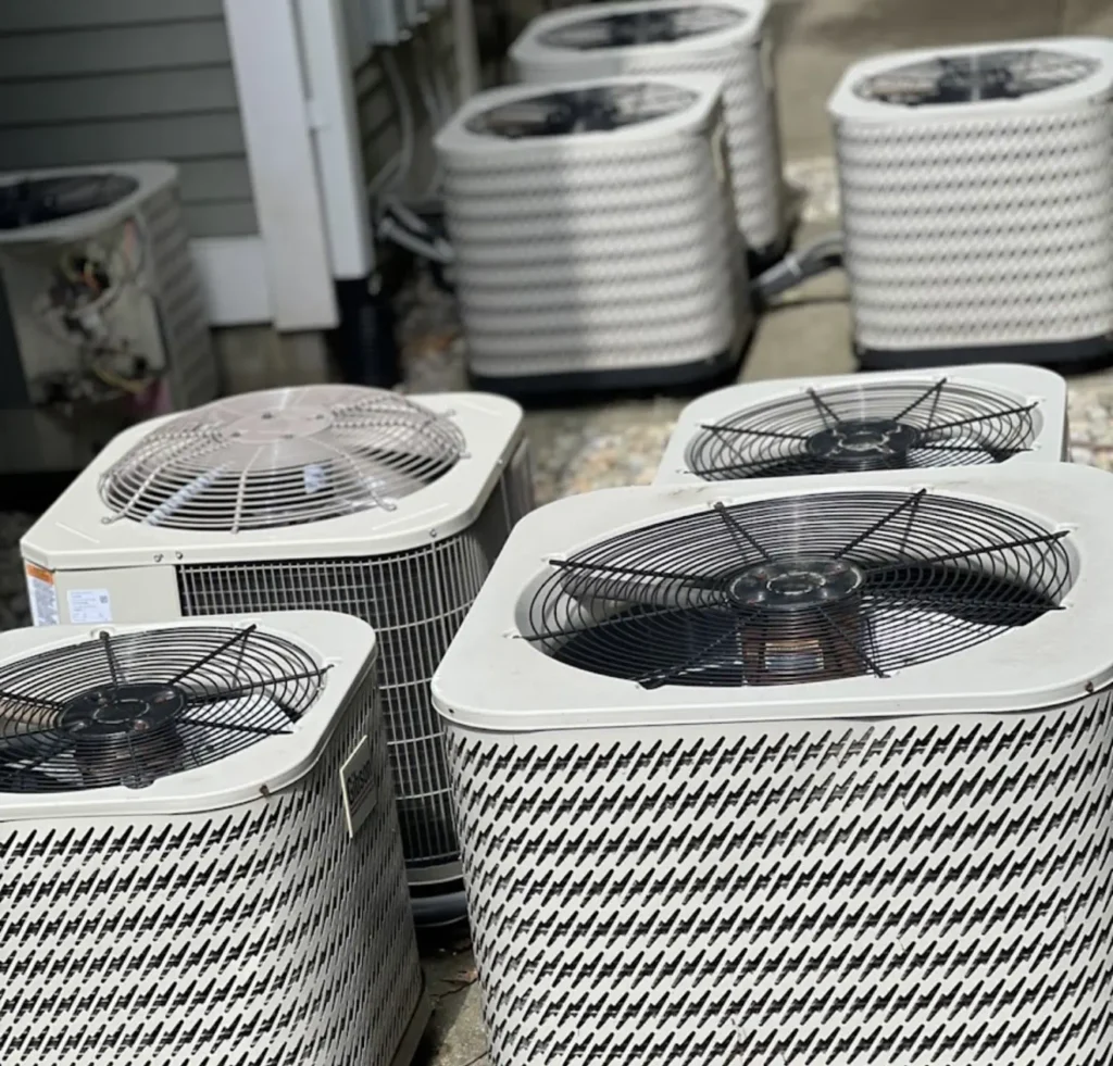 Multiple new outdoor condenser units staged for HVAC installations