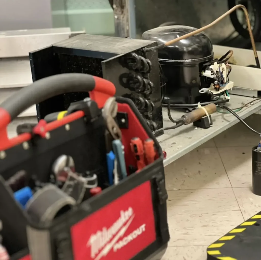 Commercial refrigeration compressor being tested with professional service tools
