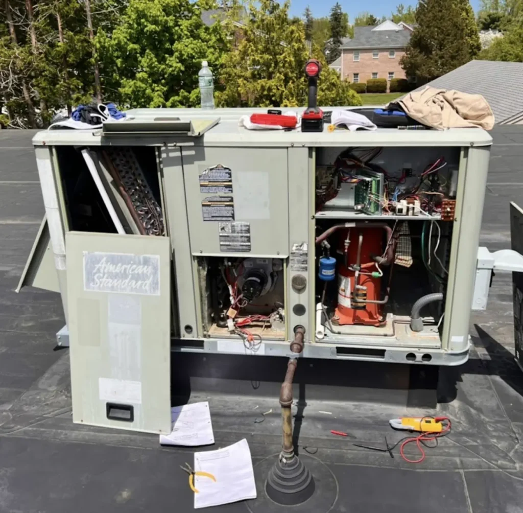 Open packaged rooftop HVAC unit with panels removed for repair
